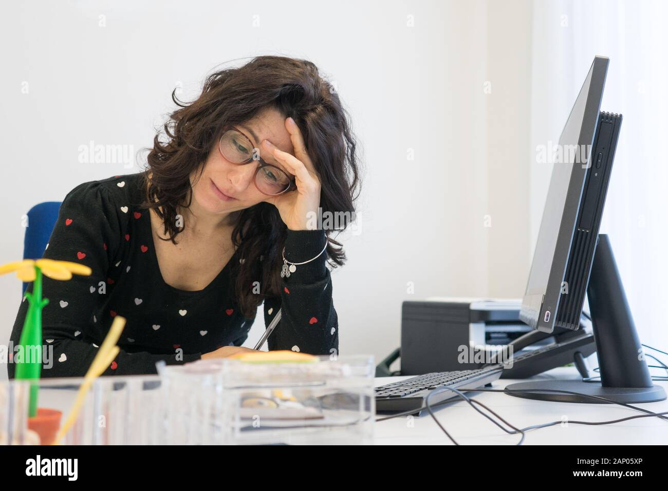 Ha sottolineato la donna al lavoro in ufficio nella parte anteriore del computer. Burn Out il concetto di sindrome Foto Stock