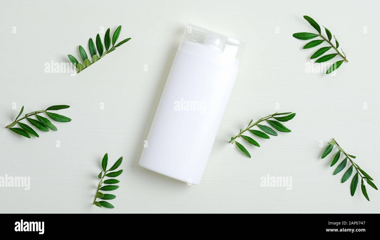 Organici di bottiglia di shampoo o lozioni per capelli il branding mockup e foglie verdi. Capelli Naturali care product design, SPA cosmetici concetto di confezionamento Foto Stock
