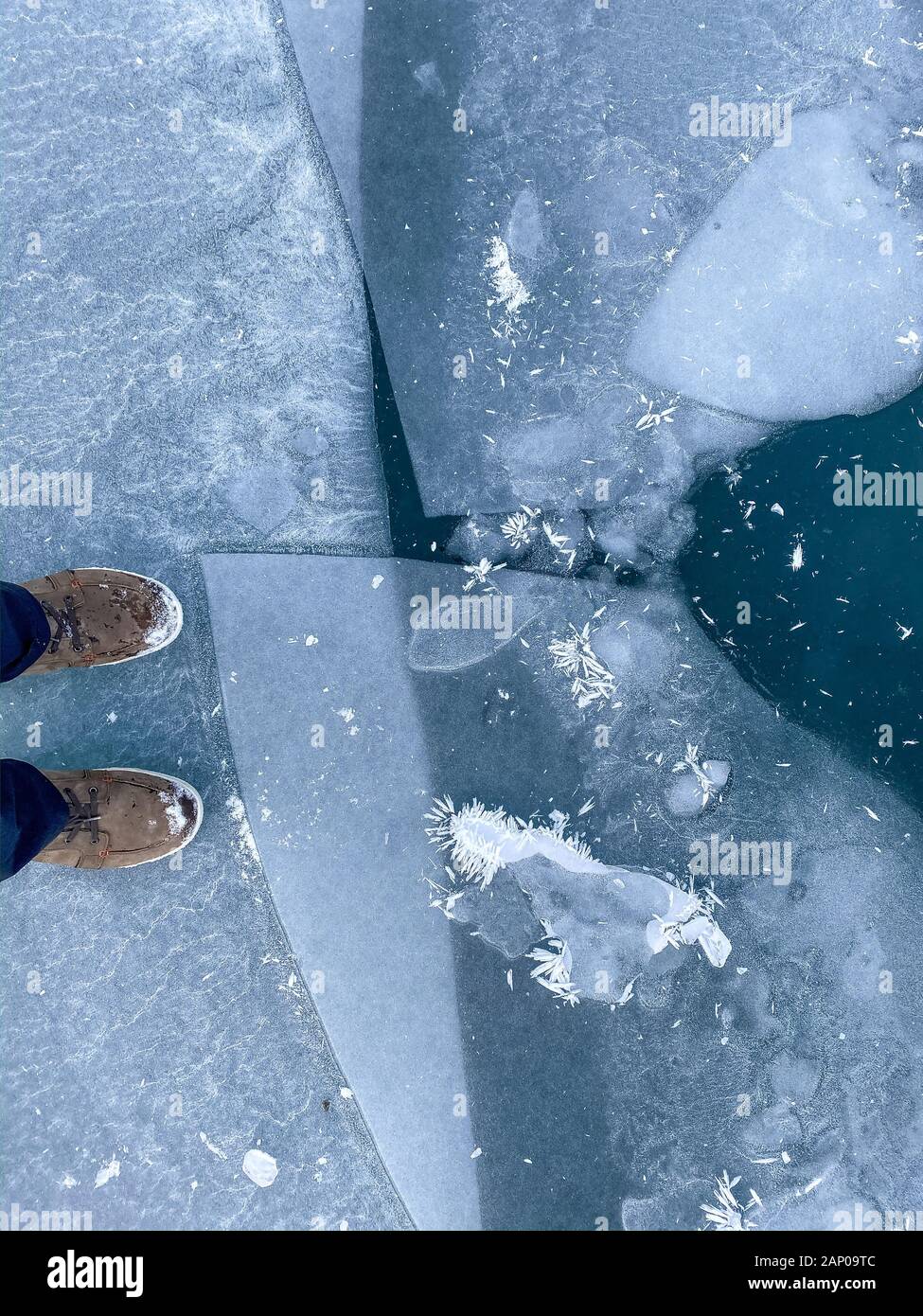 In piedi sul lago ghiacciato Oeschinensee con ice floes e ghiaccio nero Foto Stock