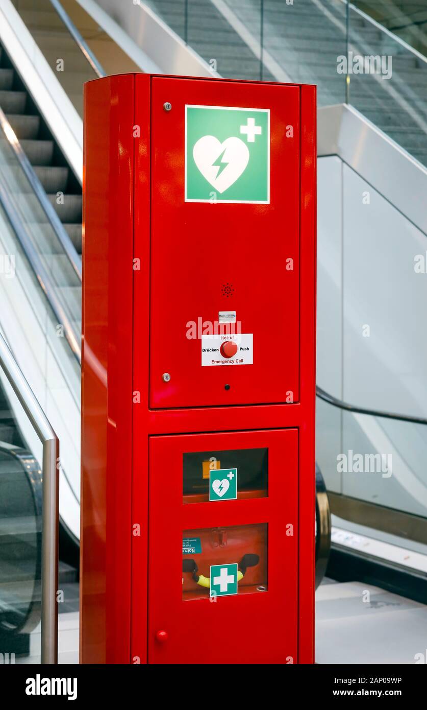 Duesseldorf, nella Renania settentrionale-Vestfalia, Germania - Rosso chiamata di emergenza colonna con defibrillatore e kit di primo soccorso in uno spazio pubblico, qui a un Escalator Foto Stock