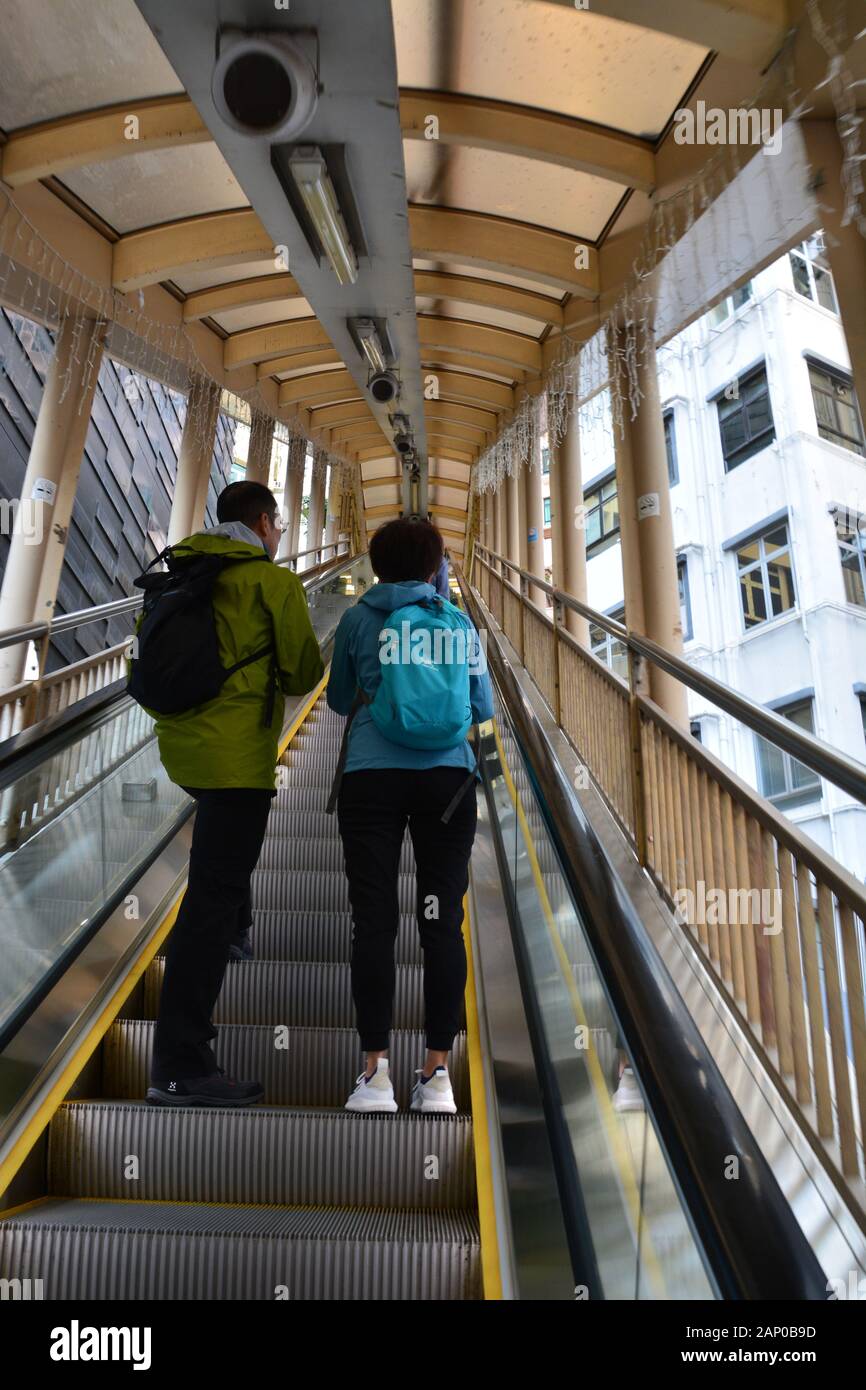 Una coppia sale le scale da Central a Mid-Levels Escalator a Hong Kong. Foto Stock