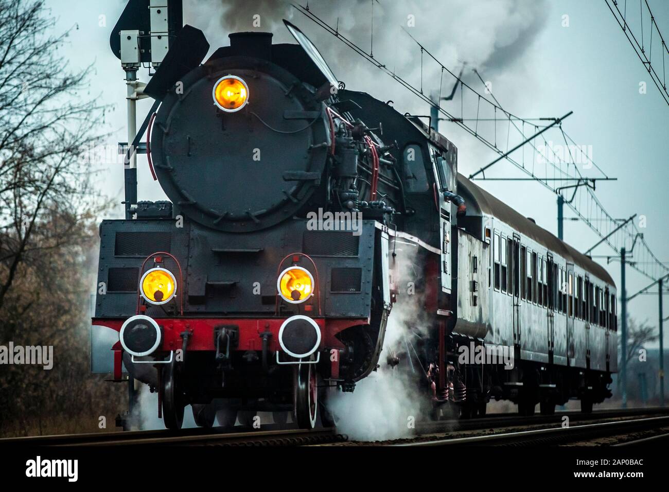 Un vecchio treno a vapore con poche autovetture che corrono su piste moderne. Foto Stock