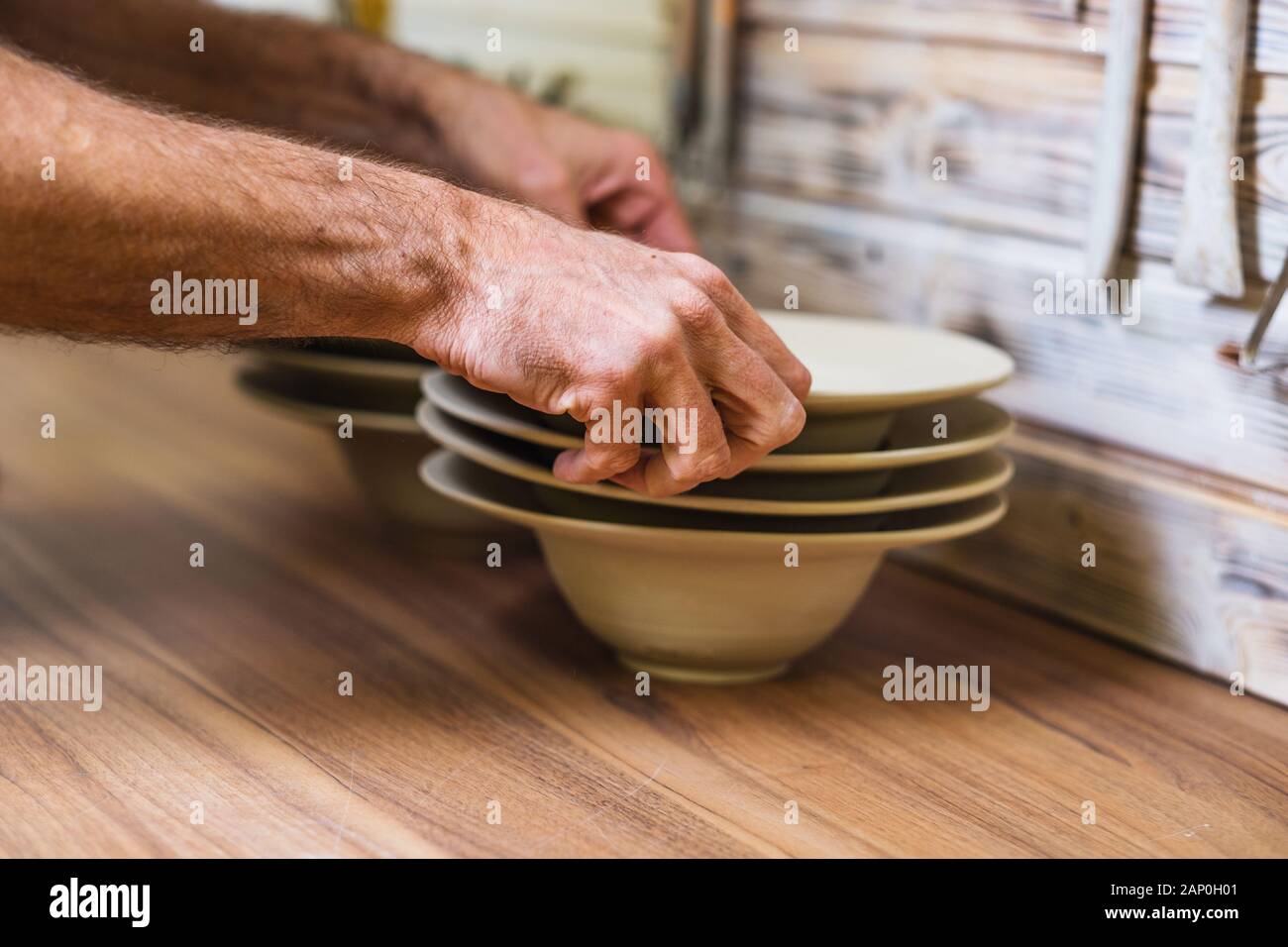 Potter in studio azienda fatto a mano le piastre, mani dettaglio, poco profondo debito di campo, piccola arte concetto di business Foto Stock