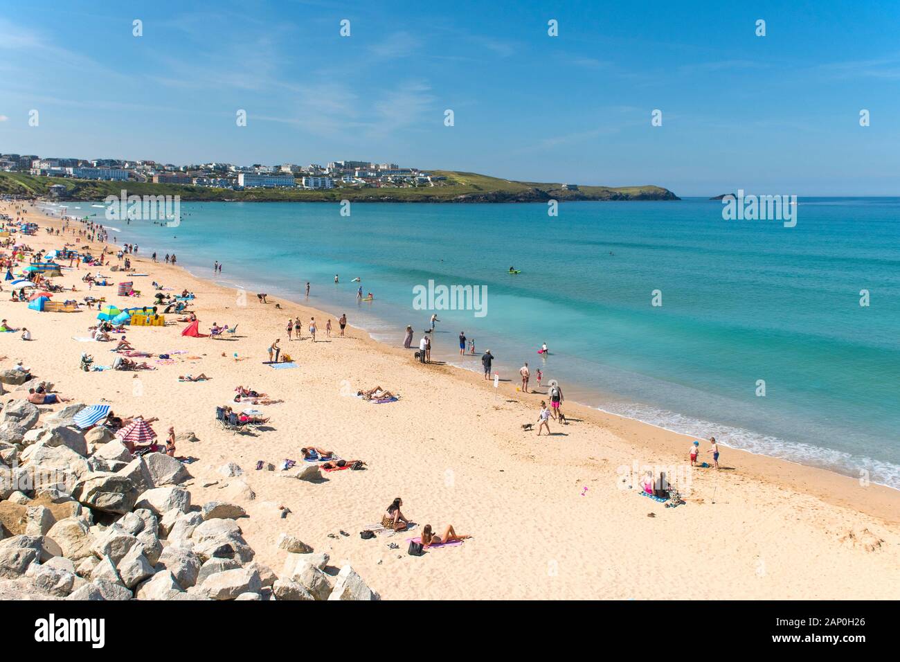 Turisti di rilassarsi e godersi il sole estivo come essi prendere il sole sulla spiaggia di Fistral a Newquay in Cornovaglia. Foto Stock