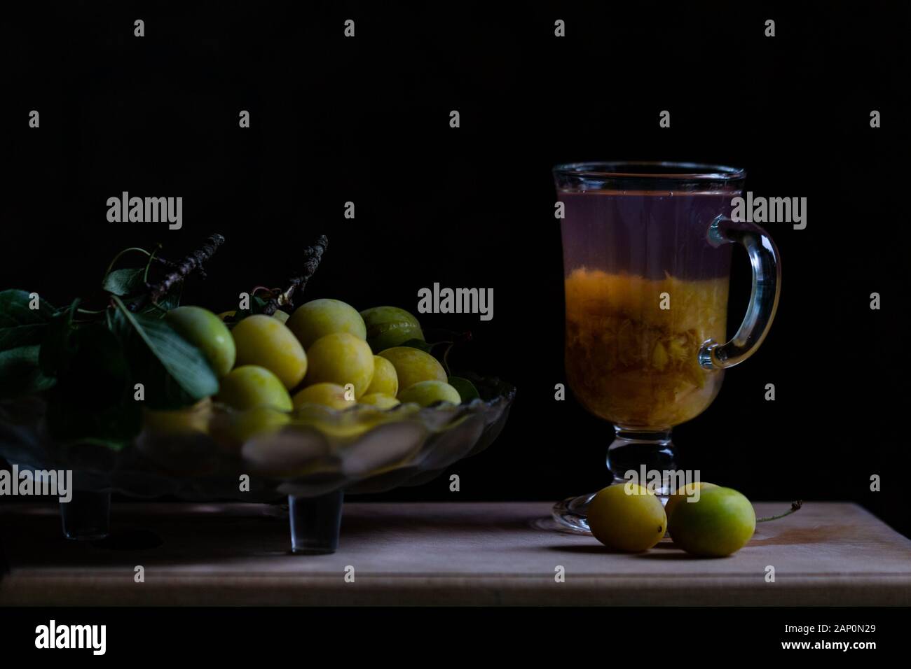 Stilllife con prugne fresche gialle e bicchiere di limonata di prugna fatta in casa Foto Stock