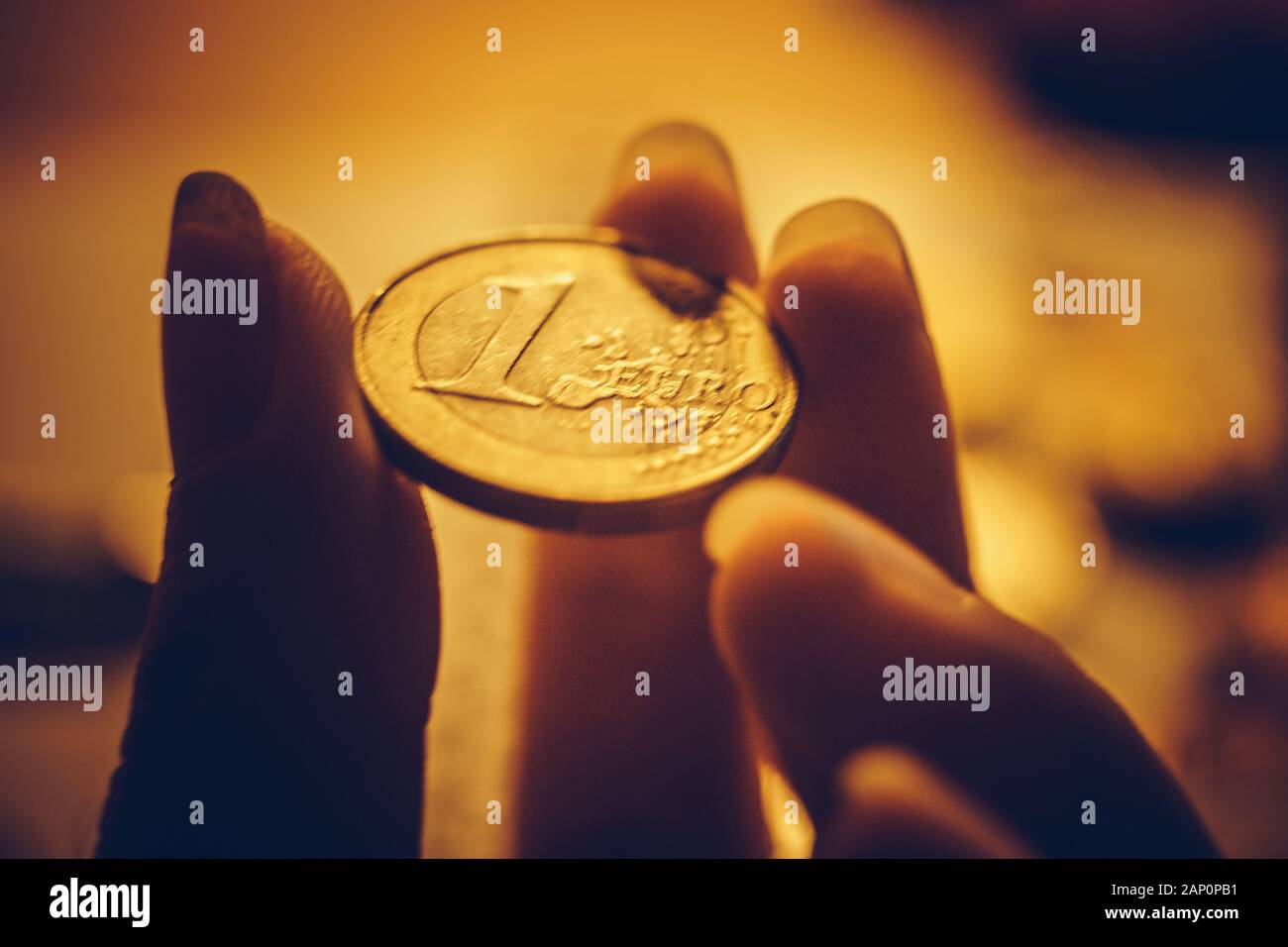 Golden 1 euro moneta nelle femmine di dita closeup Foto Stock