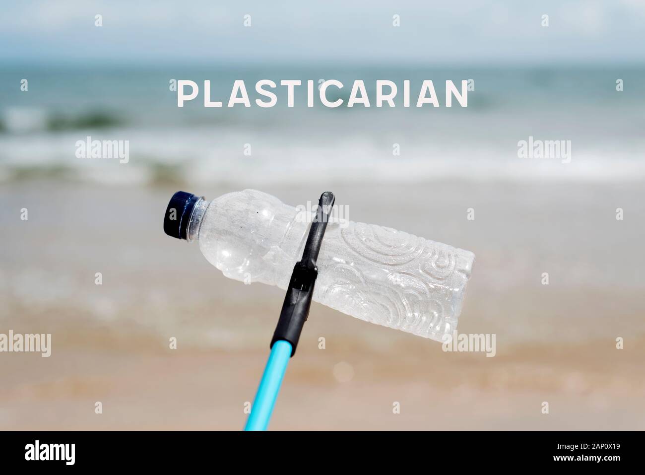 Utilizzate la bottiglia di plastica nei morsetti di un estensore di raggiungere nel corso di una pulizia in una spiaggia e la parola plasticarian, un neologismo per quelle persone che cercano di un Foto Stock