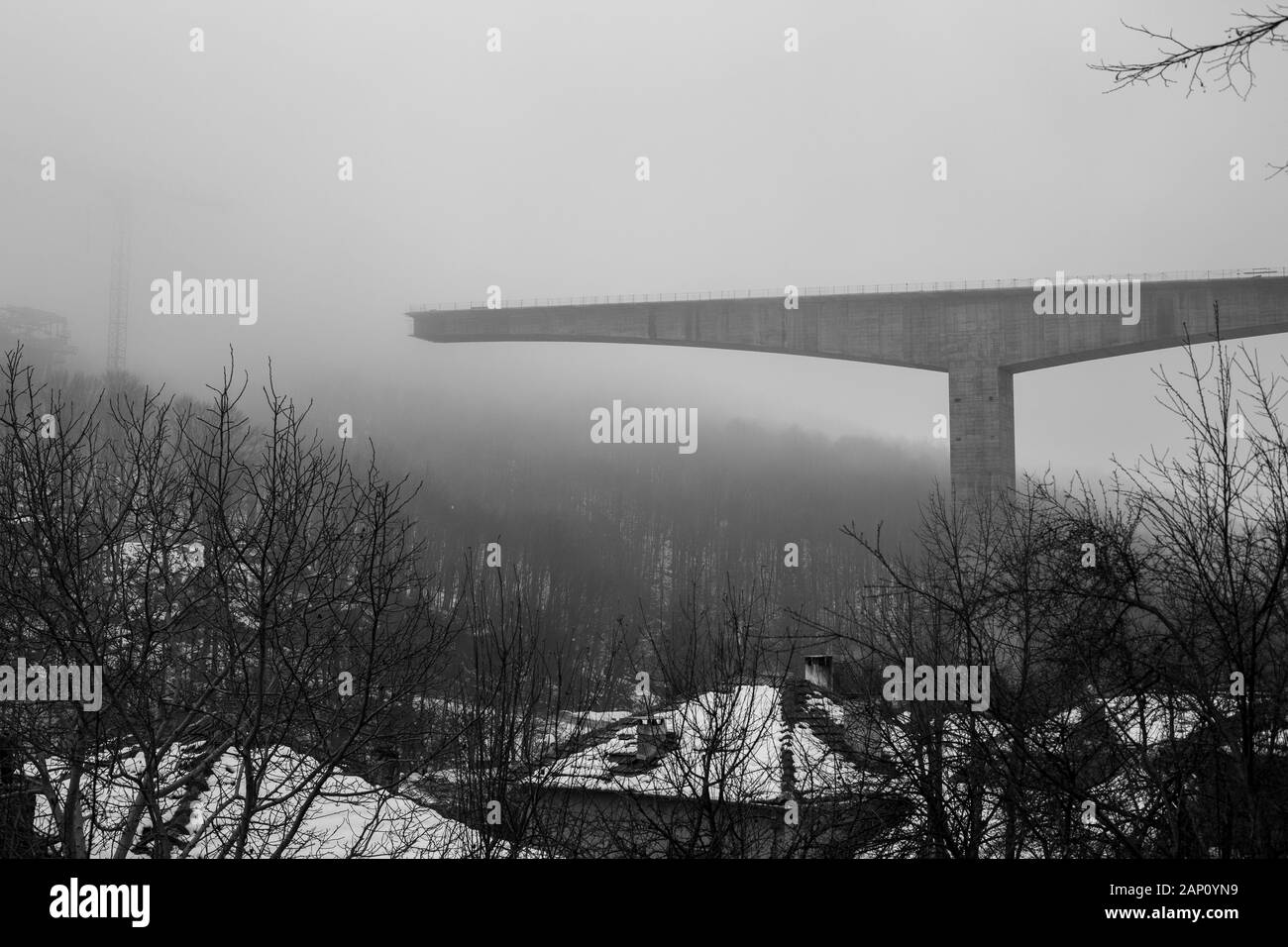 Fitta nebbia invernale e costruzione di ponti in cemento ad alta velocità nella città di Gabrovo, nel nord della Bulgaria, in Europa. Parte della circonvallazione, sponsorizzata dall'Unione europea. Immagine in bianco e nero Foto Stock