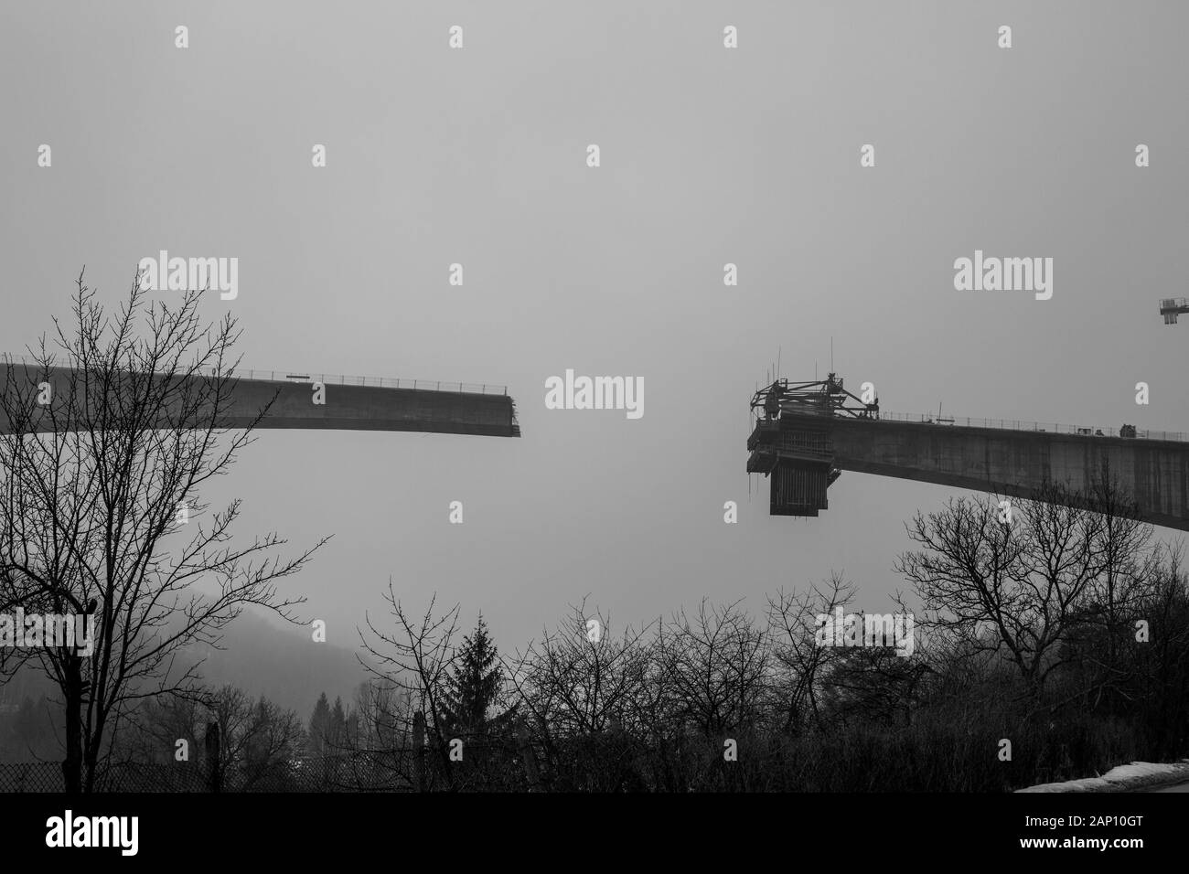 Fitta nebbia invernale e costruzione di ponti in cemento ad alta velocità nella città di Gabrovo, nel nord della Bulgaria, in Europa. Parte della circonvallazione, sponsorizzata dall'Unione europea. Immagine in bianco e nero Foto Stock
