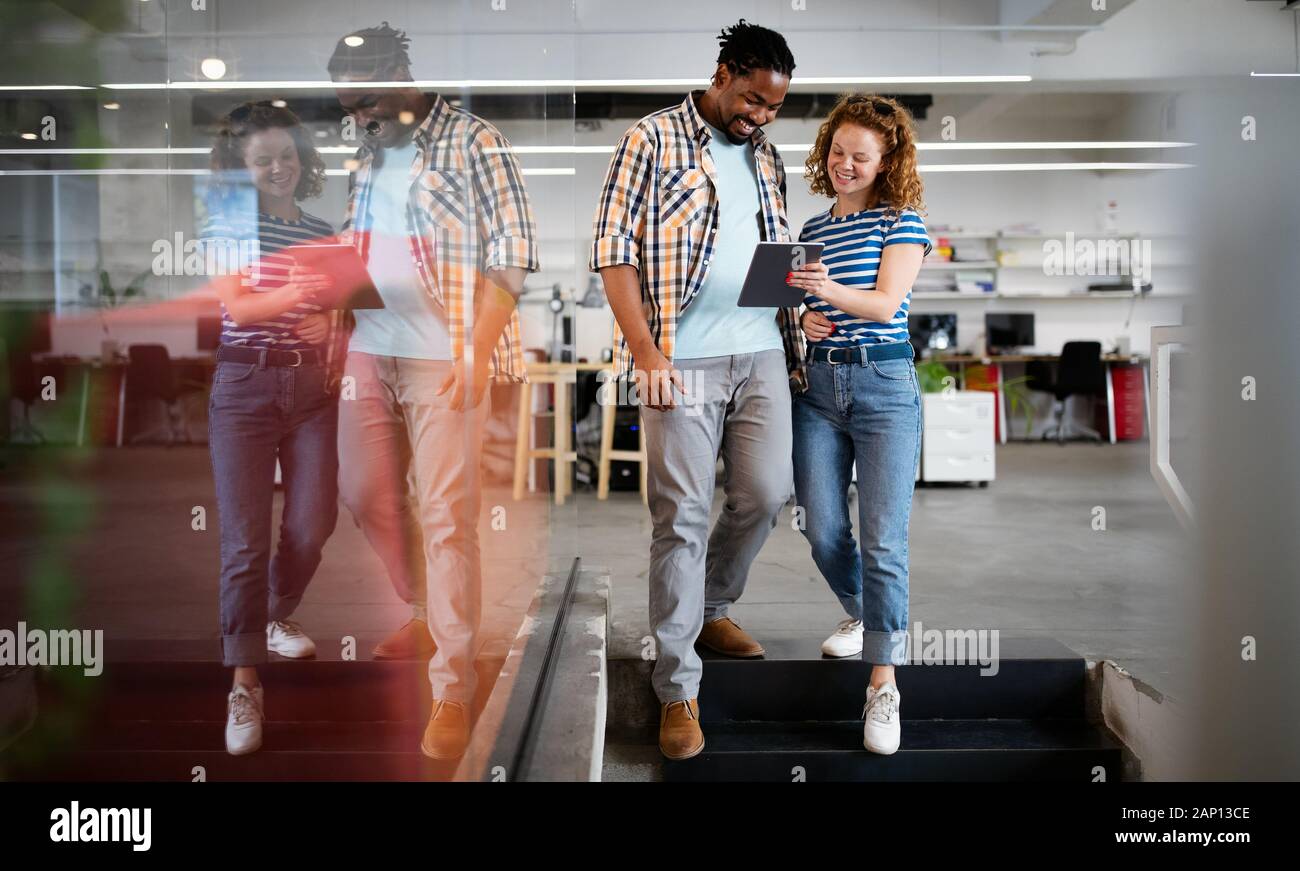 I colleghi discutere di affari e sorridenti mentre si cammina attraverso il corridoio di office Foto Stock
