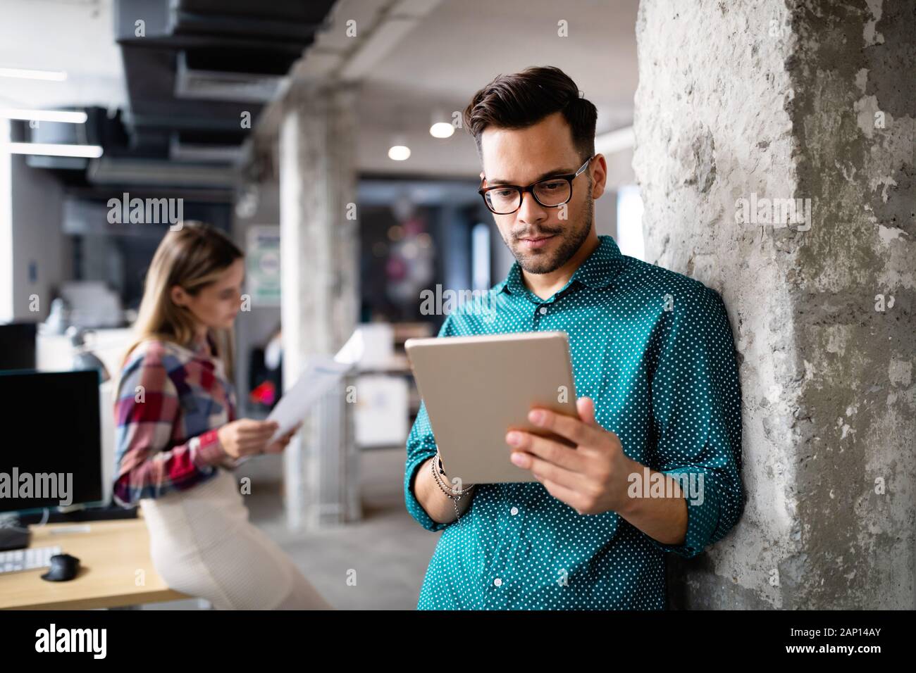 Giovane uomo utilizzando la tecnologia digitale compressa in corporate business office Foto Stock