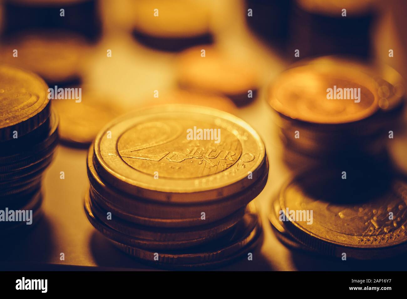 Pile di ferro delle monete in euro al buio su un tavolo. Foto Stock