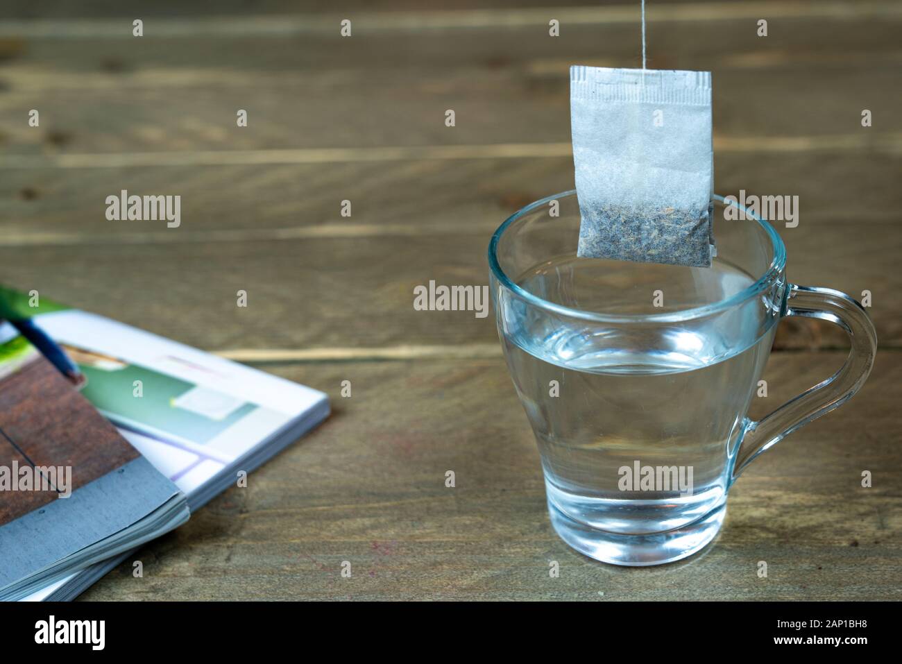 borsa da tè appesa su un bicchiere di acqua calda. Preparazione del tè. Foto Stock