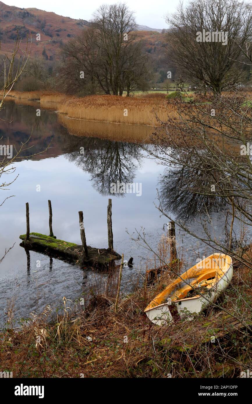 Molo di Rotten e barca allagata. Foto Stock