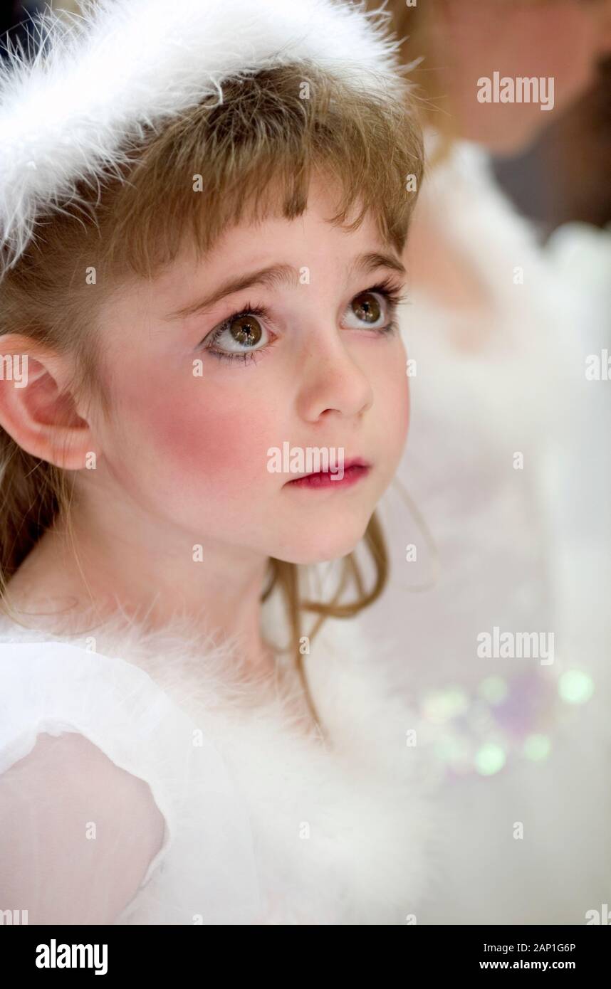 Angelic bambina vestito come un angelo visto in un corteo di Natale Foto Stock