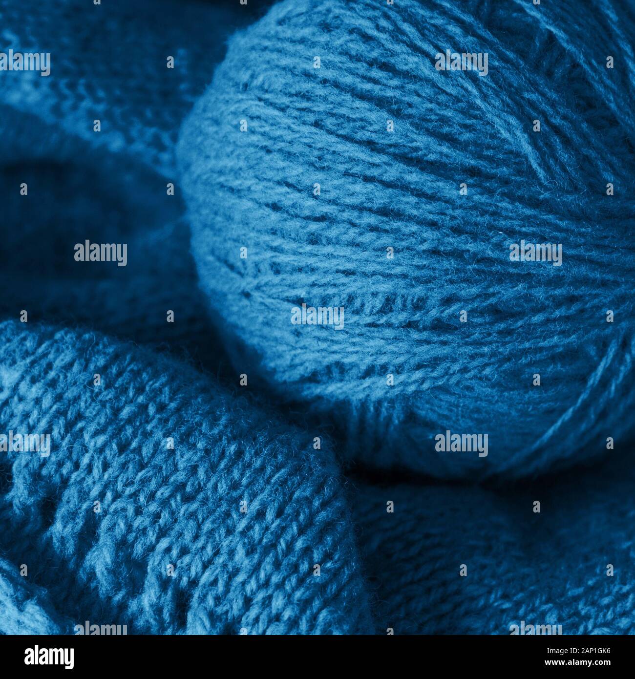 Il processo di lavorazione a maglia, filati di lana classico di colore blu sul tavolo blu. Foto Stock