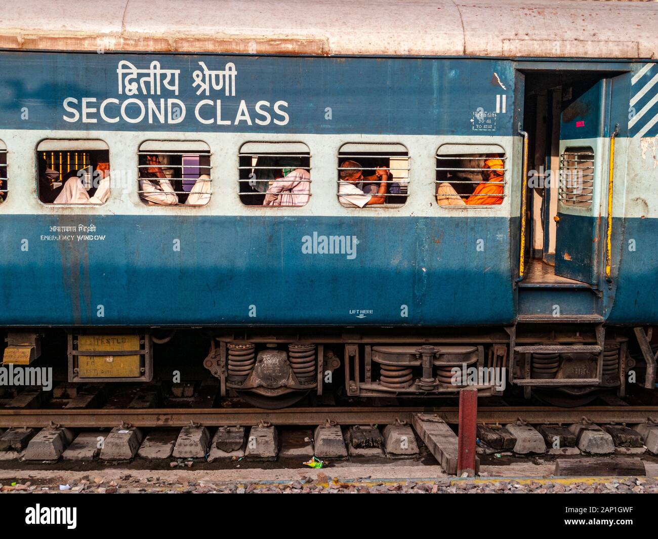 Bar per la sicurezza di fronte alle finestre di un pullman ferroviario indiano, i passeggeri stanno guardando fuori Foto Stock