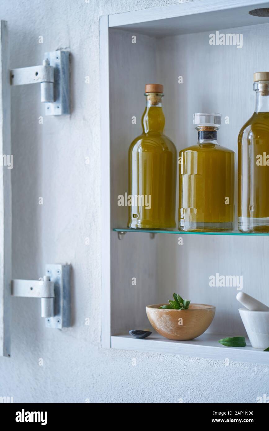 bottiglie olio di oliva oli primo piano ripiano cucina dettaglio cibo naturale bellezza biologica casa paese sano elegante ciotola bianca verticale formato Foto Stock