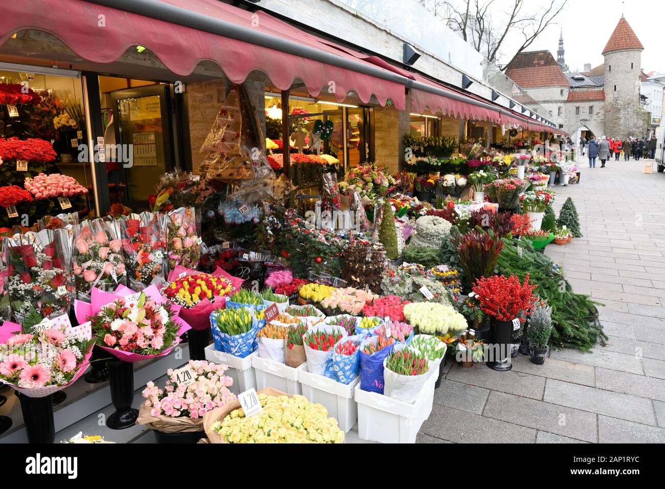 Mercato dei fiori invernali in Piazza Viru, con Torre Viru e porta Viru sullo sfondo. Tallinn, Estonia Foto Stock