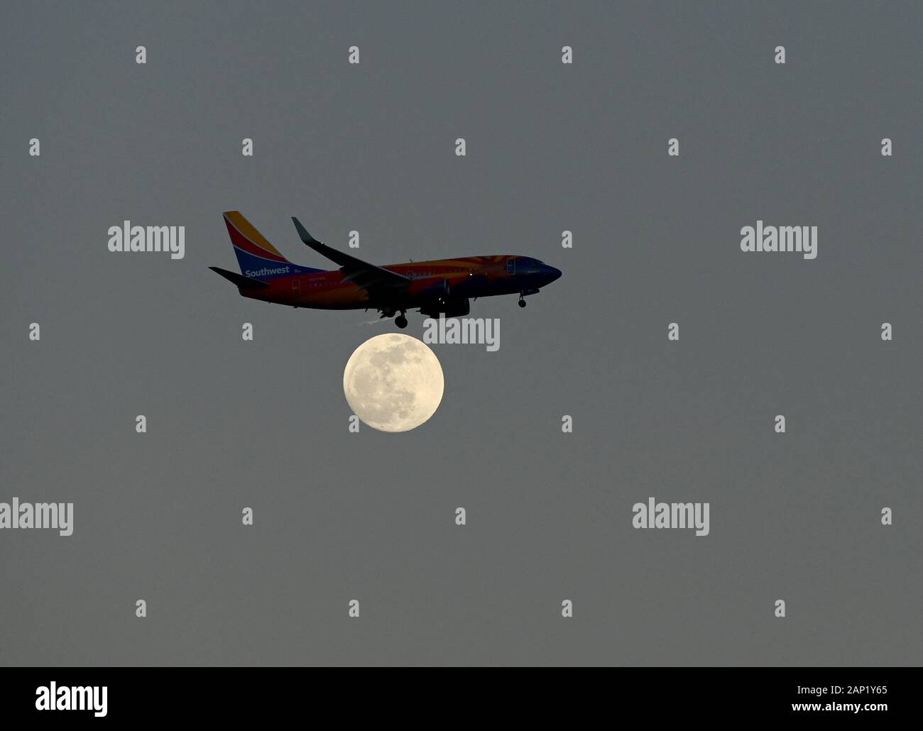 Un aereo della Southwest Airlines Boeing 737-700 atterra su una luna piena vicino all'Aeroporto Internazionale di Orlando o MCO. Foto Stock