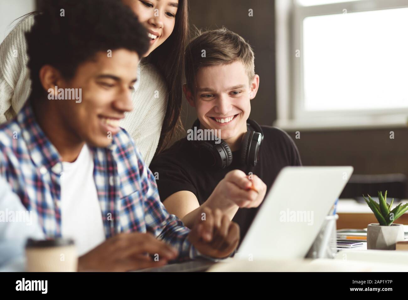 I compagni di scuola universitaria facendo un progetto con il computer portatile Foto Stock