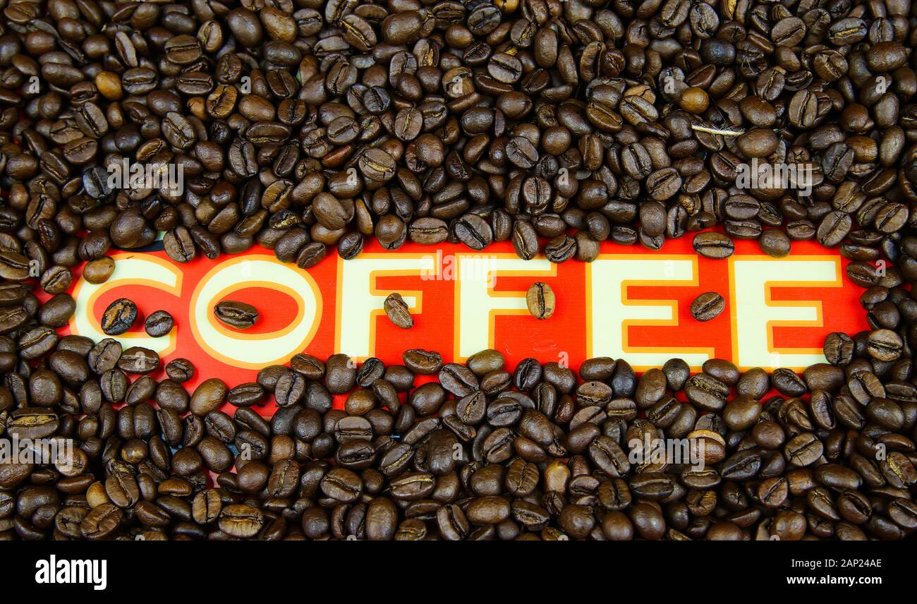 Isolato di singola parola caffè bianco su rosso terra con Roasted Brown innumerevoli semi telaio Foto Stock