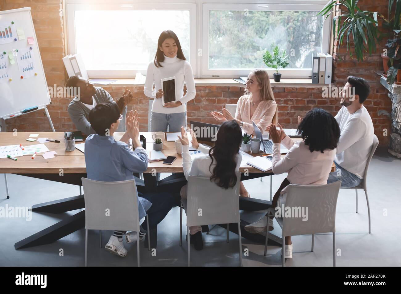 Lavoratori asiatici rendendo la presentazione al meeting aziendale, utilizzando tablet Foto Stock