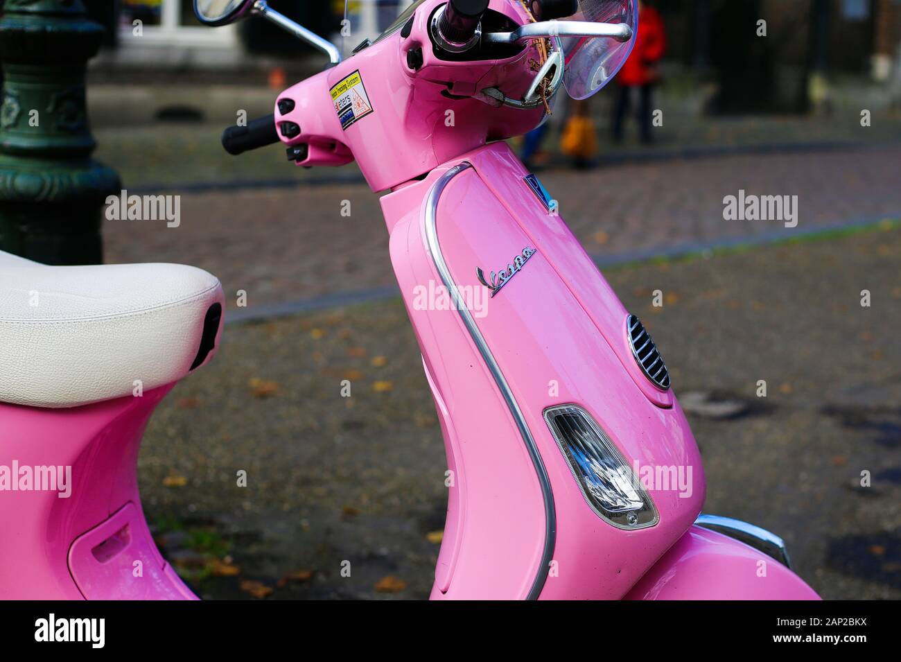 Maastricht, Paesi Bassi - 30 novembre. 2019: vista laterale sul retro rosa scooter Vespa parcheggiata su city square Foto Stock