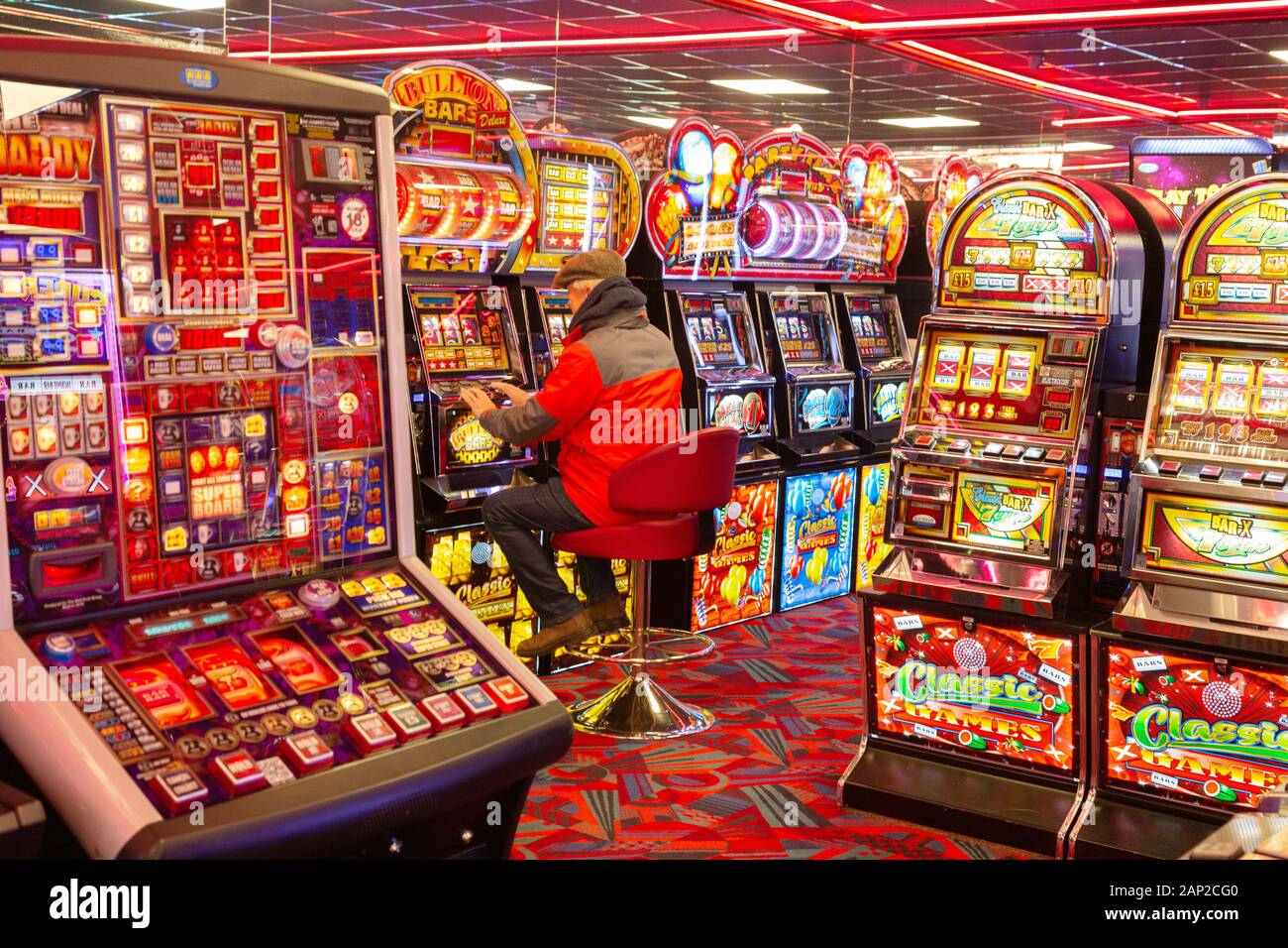 Gioco d'azzardo UK - un uomo che gioca slot machine in un casinò, esempio di uno stile di vita del gioco d'azzardo; Skegness Lincolnshire Inghilterra UK Foto Stock