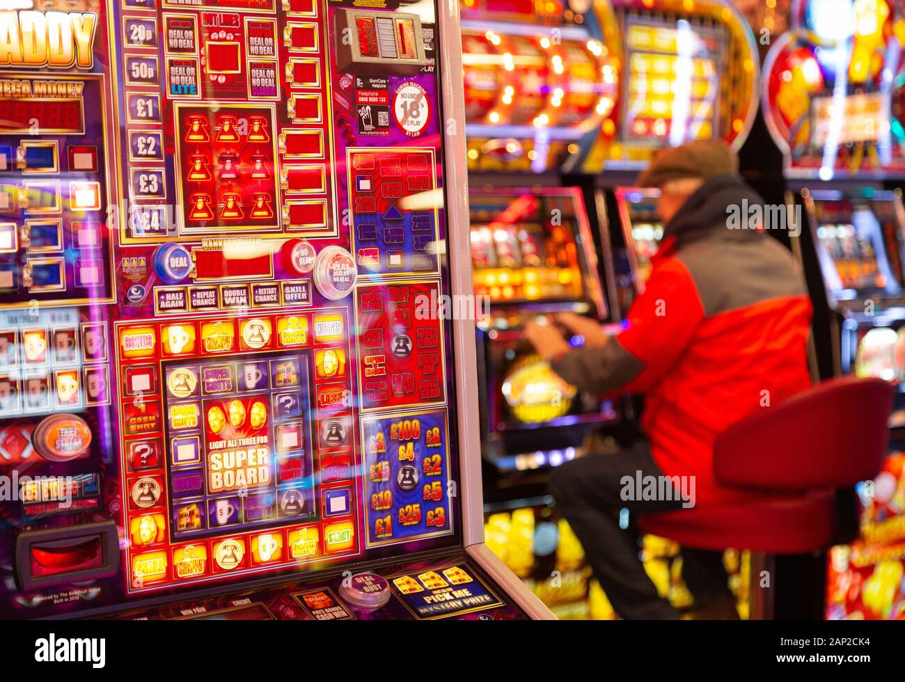 Gioco d'azzardo UK - un uomo che gioca slot machine in un casinò, esempio di uno stile di vita del gioco d'azzardo; Skegness Lincolnshire Inghilterra UK Foto Stock