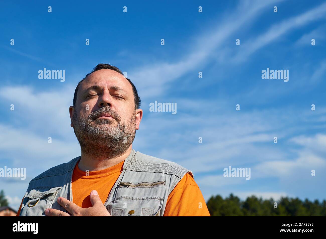 Uomo di assorbimento di raggi di sole e godere dell'atmosfera calma Foto Stock