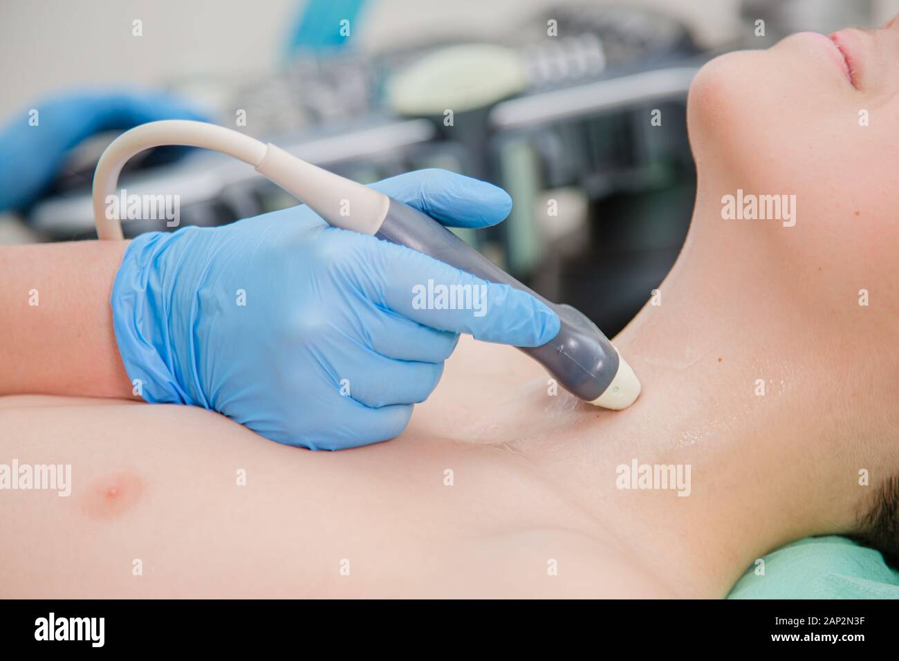 Medico donna esamina la ghiandola tiroide con un scanner ad ultrasuoni. La diagnosi clinica e della ricerca. Foto Stock