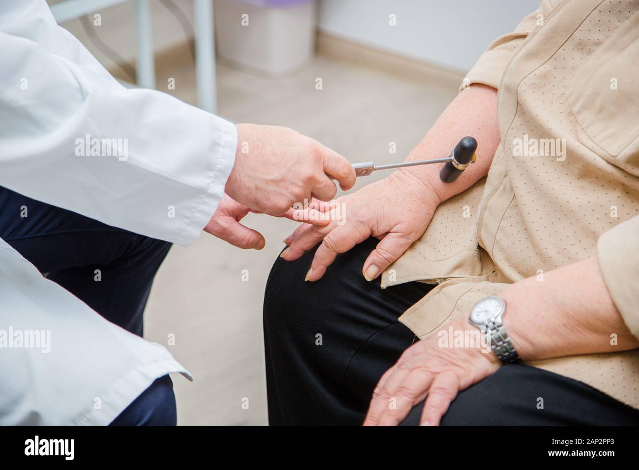 Chirurgo ortopedico esaminando il ginocchio reflex. Il medico controlla il riflesso fisiologico, il martello in prova. Il controllo medico dei riflessi Foto Stock