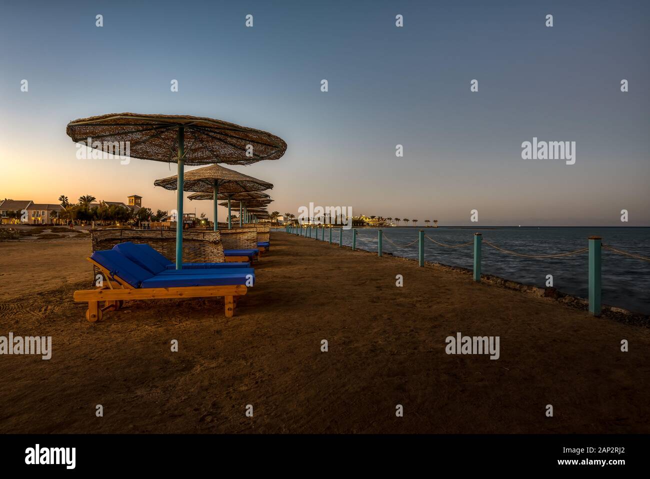 Sedie a sdraio e ombrelloni una sera al tramonto lungo la costa in El Gouna, Egitto, 6 gennaio 2020 Foto Stock