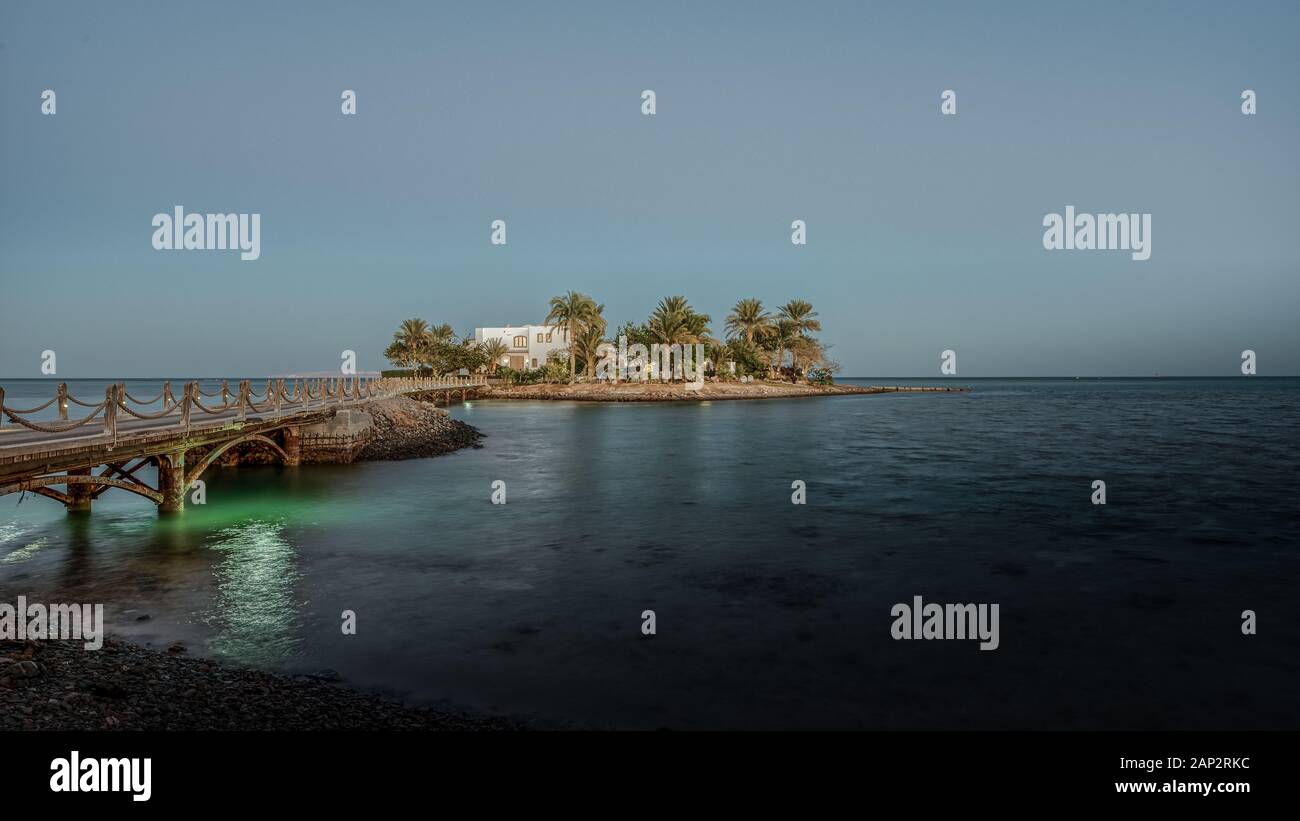 La villa bianca su una piccola isola con palme e un ponte nel crepuscolo della luce della sera, El Guna, Egitto, 07 Gennaio 2020 Foto Stock