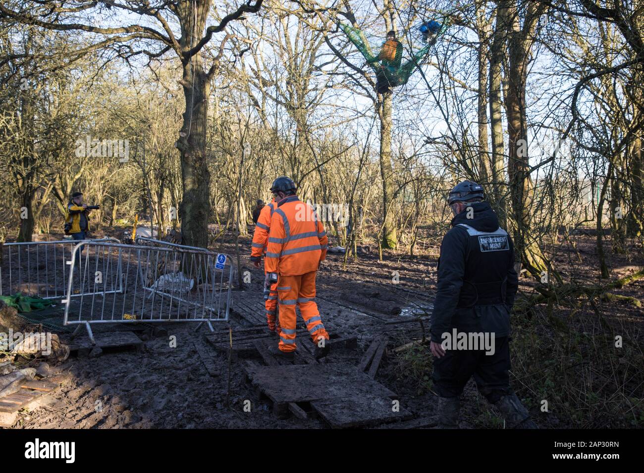 Harefield, UK. Il 20 gennaio, 2020. Esecuzione agenti che agiscono per conto di HS2 immettere la strada Harvil la tutela della fauna selvatica camp che fu rioccupata dagli attivisti dalla ribellione di estinzione, Stop HS2 e salvare il Colne Valley due giorni in precedenza. Alcuni attivisti, che cercano di proteggere antichi boschi minacciato dal collegamento ferroviario ad alta velocità, erano state sfrattate dal campo nel corso delle due settimane precedenti. Credito: Mark Kerrison/Alamy Live News Foto Stock