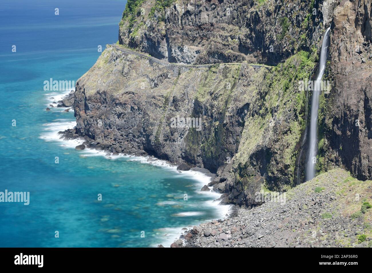 Ripide scogliere costiere e l'iconica cascata dell'oceano a Véu da Noiva, Madeira, catturata con texture drammatiche e vivaci tonalità atlantiche. Foto Stock