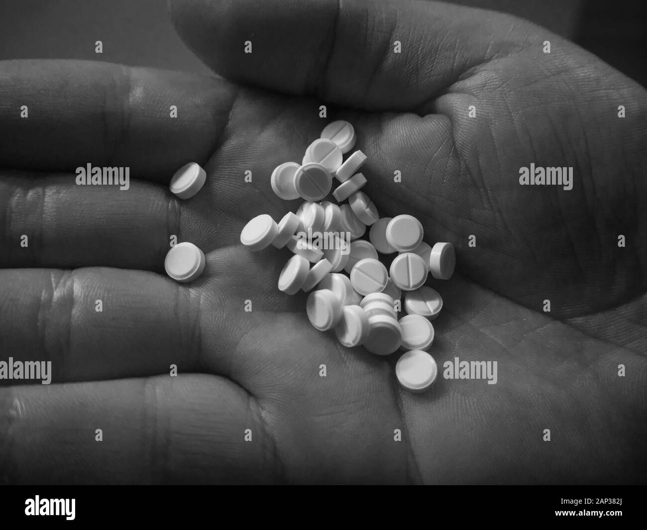 Una manciata di pillole in mano la fotografia in bianco e nero Foto Stock