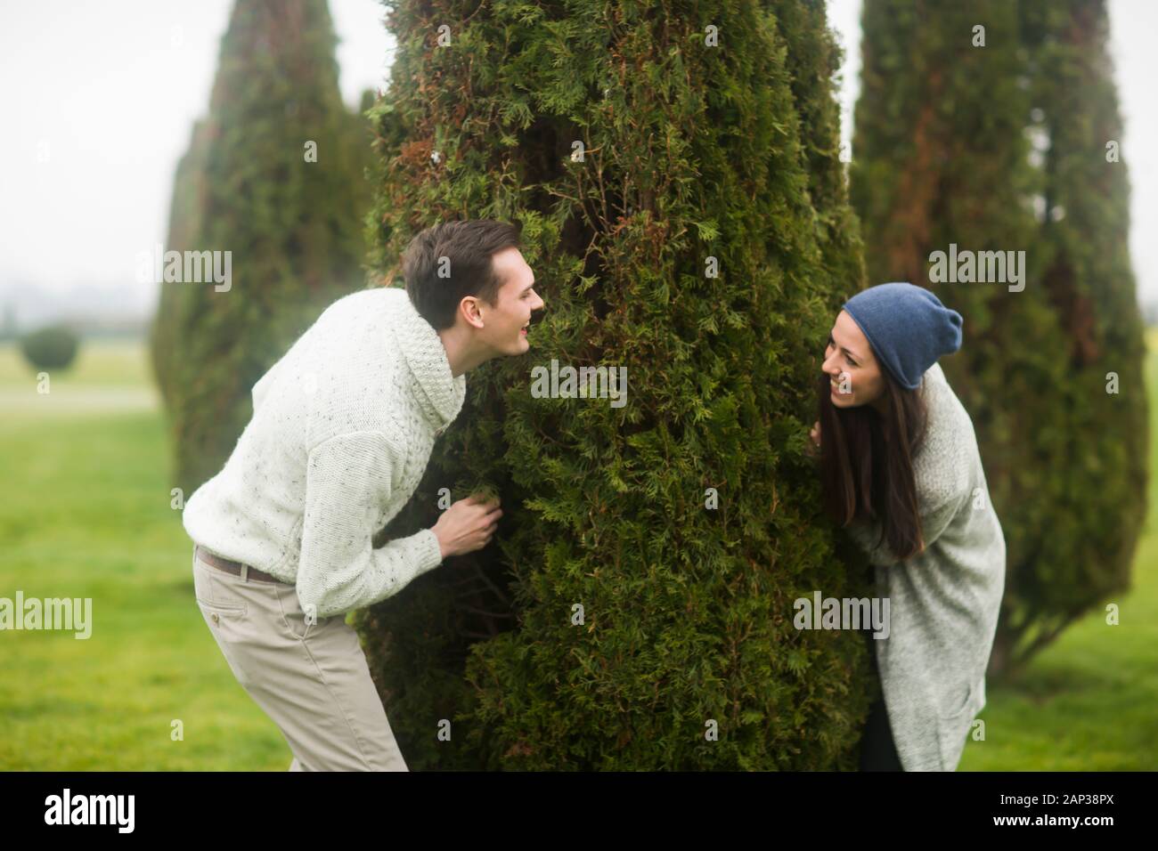 giovane coppia fuori giocare una partita intorno ad un albero Foto Stock