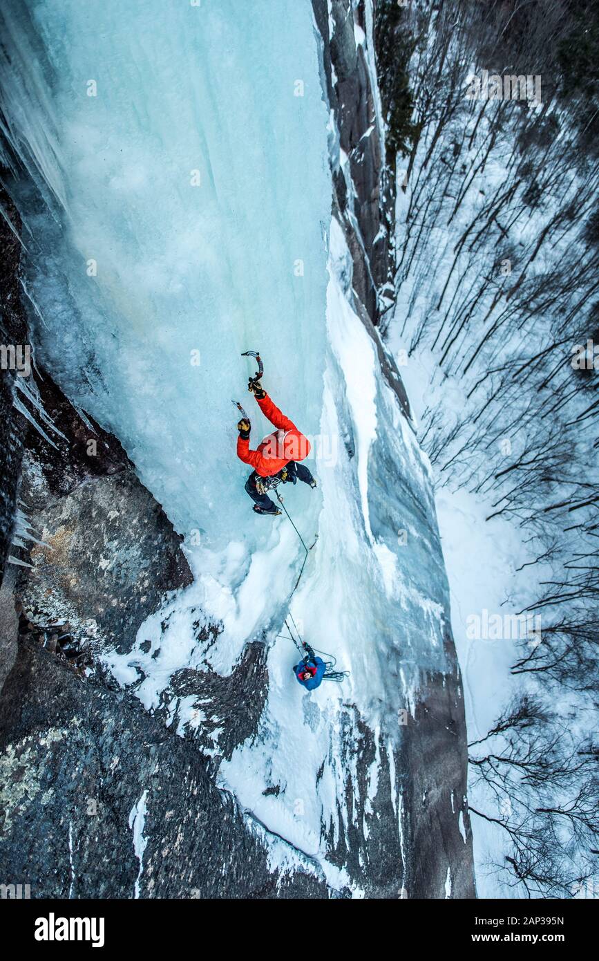 Uomo arrampicata su ghiaccio sulla sporgenza della Cattedrale a North Conway, New Hampshire Foto Stock