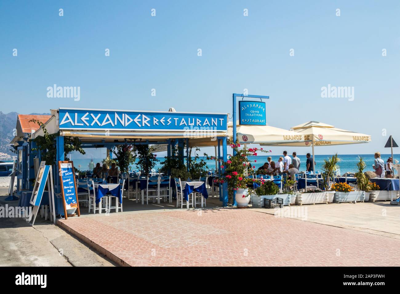 Kardamaina, Kos, Grecia - 20 Settembre 2019: la gente camminare lungo la passeggiata oltre il Ristorante Alexander. La città è famosa per le vacanze destina Foto Stock