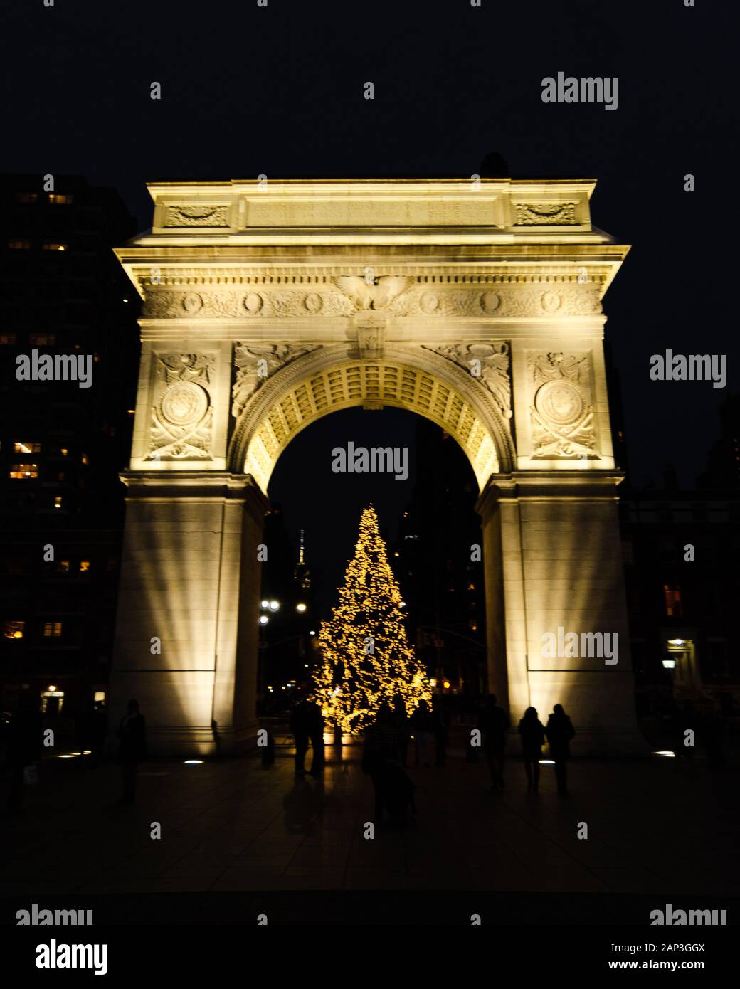 Vista frontale del Washington Square Arch nel Washington Park con un albero di Natale sotto illuminato di notte a Manhattan, New York, NY Foto Stock