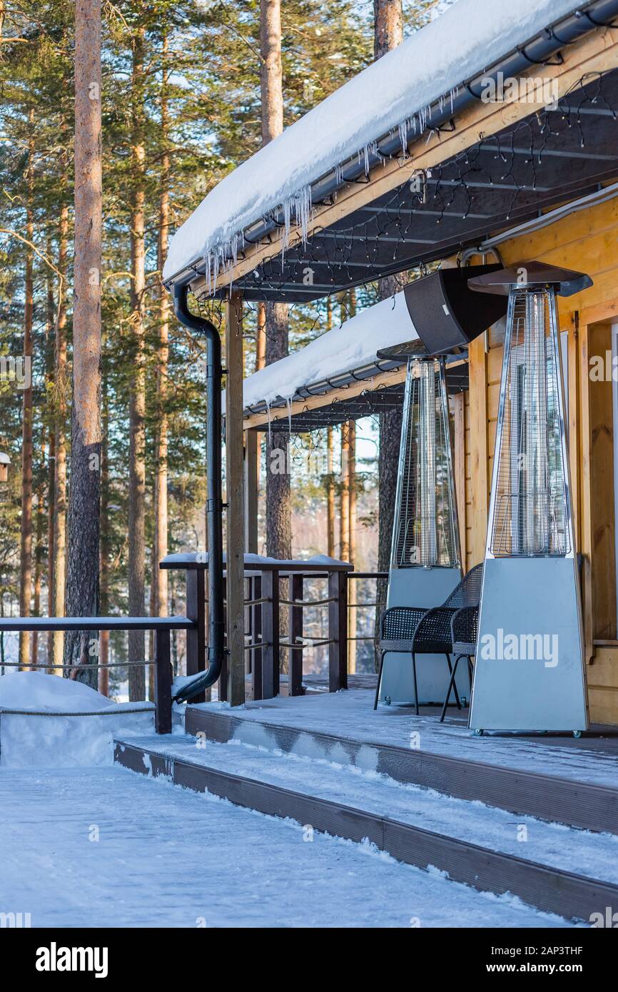 Lampada di riscaldamento collocato tra i tavoli di un cafe aperto Foto Stock