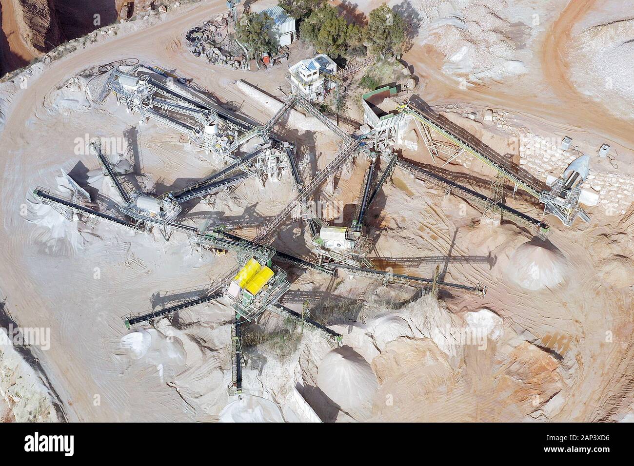 Vista aerea di una grande cava durante le ore di lavoro con nastri trasportatori per la selezione della pietra Foto Stock