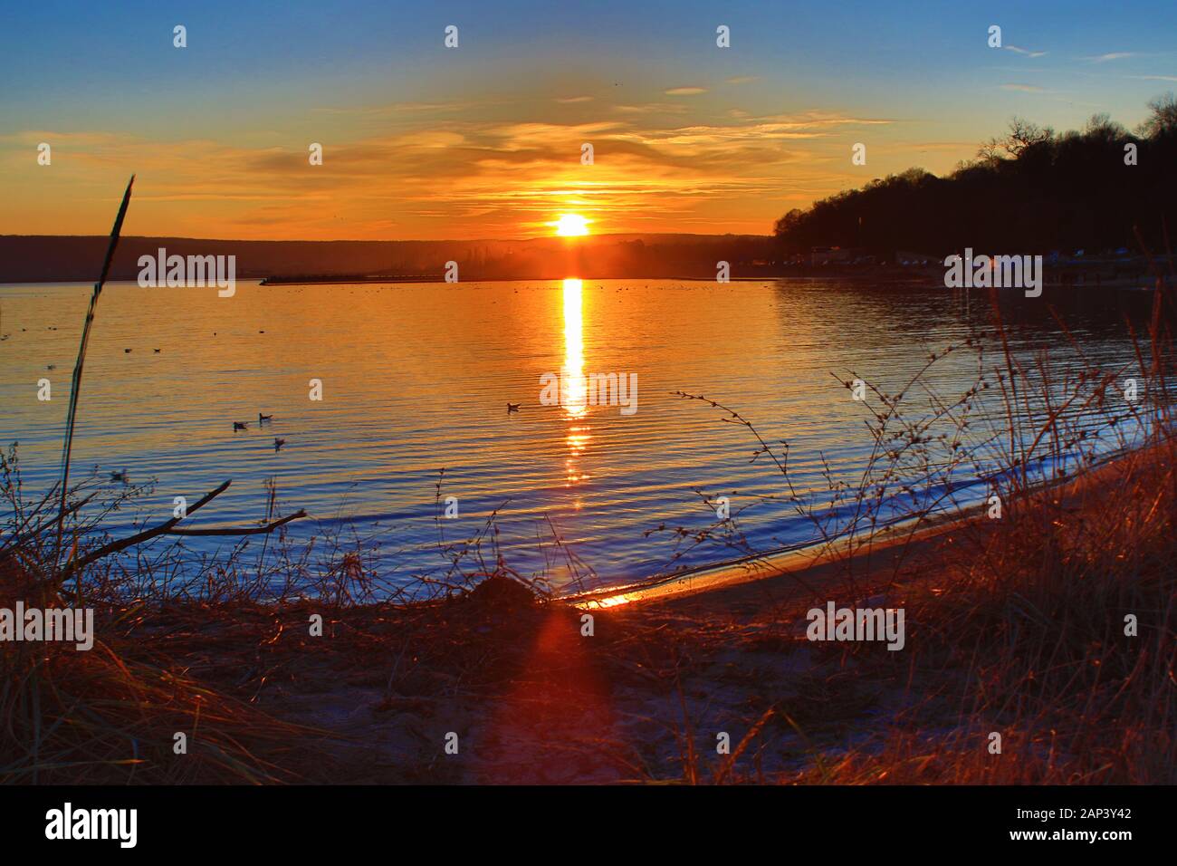 Tramonto sul lungomare della città di Varna, il porto di Varna in lontananza, costa del Mar Nero Bulgaria Foto Stock