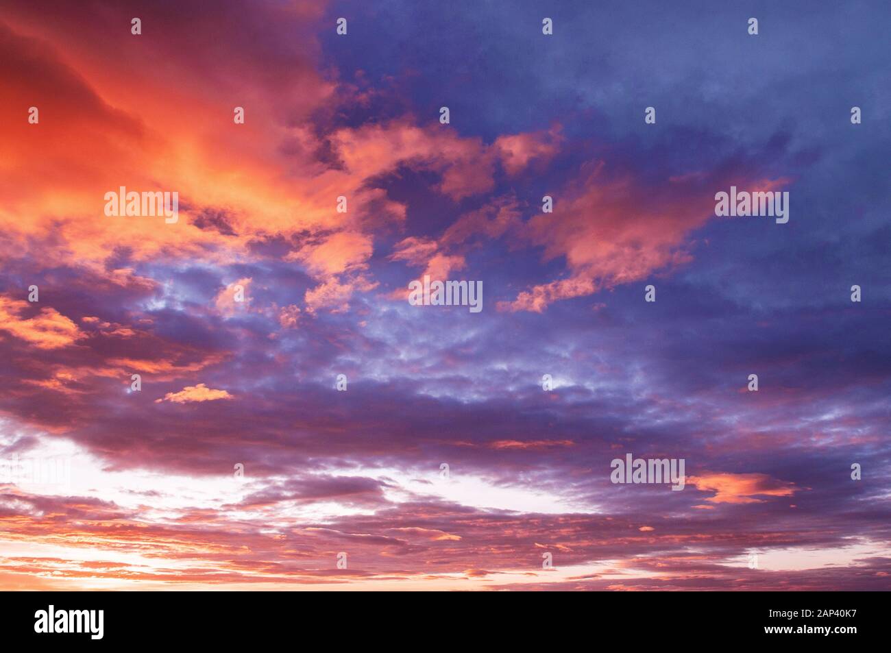 Bella estate due toni rosso acceso tramonto o alba cielo con nuvole sparse Foto Stock
