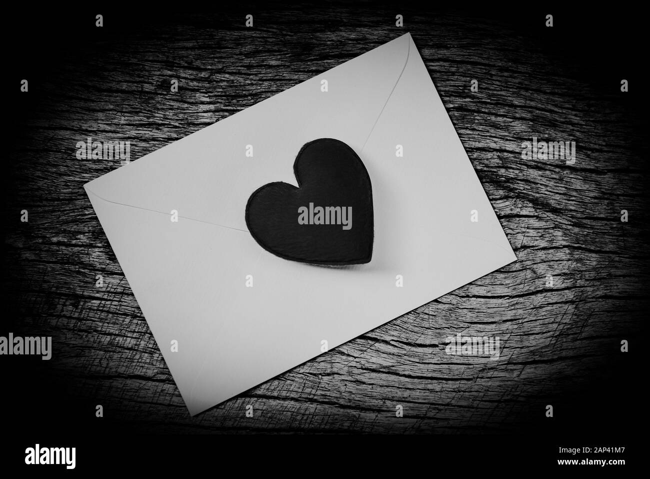 Amore romantico San Valentino di carta Lettera busta posta con cuore nero / scheda di invito wedding su uno sfondo di legno , cuore monocromatico Foto Stock