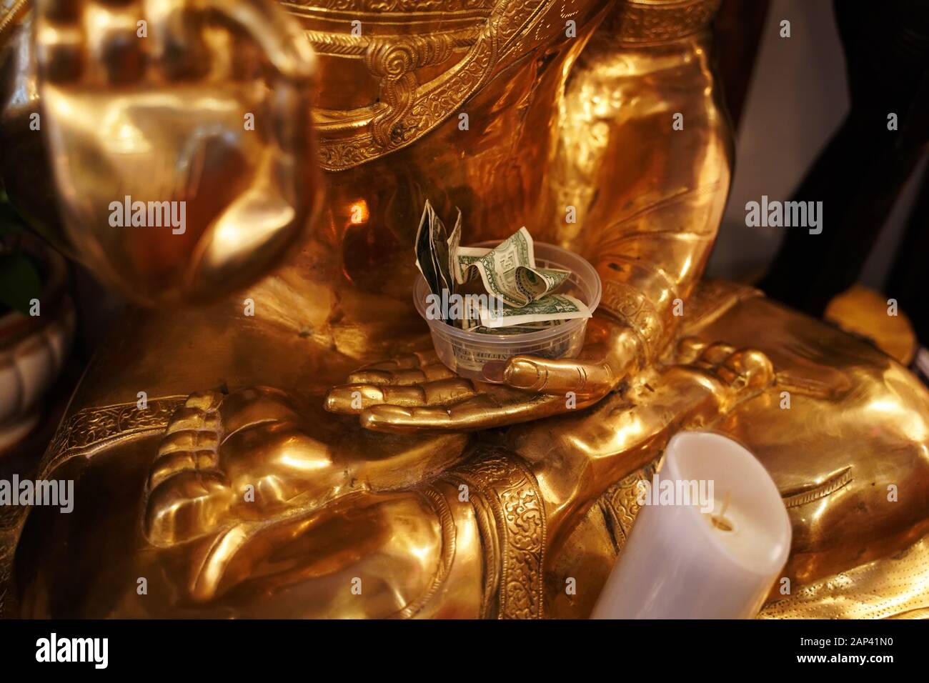 Dollaro fatture in un contenitore di plastica nella mano di Lakshmi, dea indù di ricchezza, fortuna e prosperità. Foto Stock