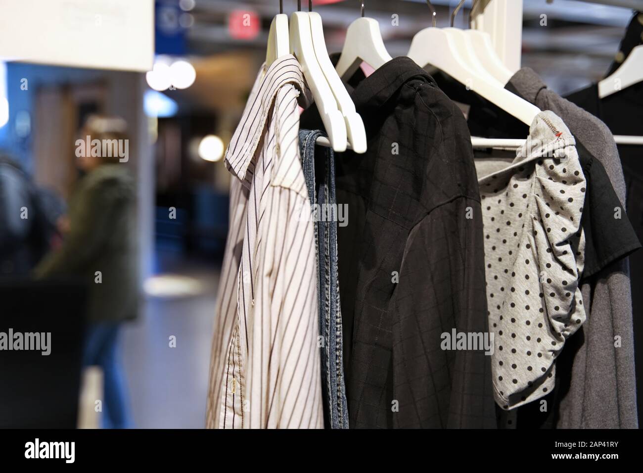 Esporre abiti su appendiabiti in un negozio di organizzazione. Foto Stock