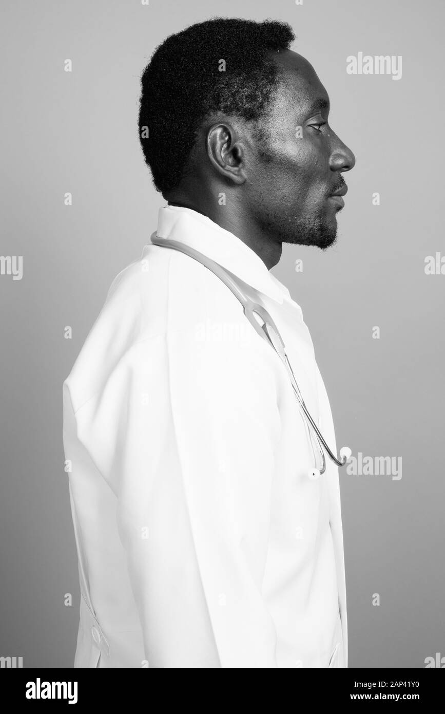 Bel giovane uomo africano medico contro uno sfondo grigio Foto Stock